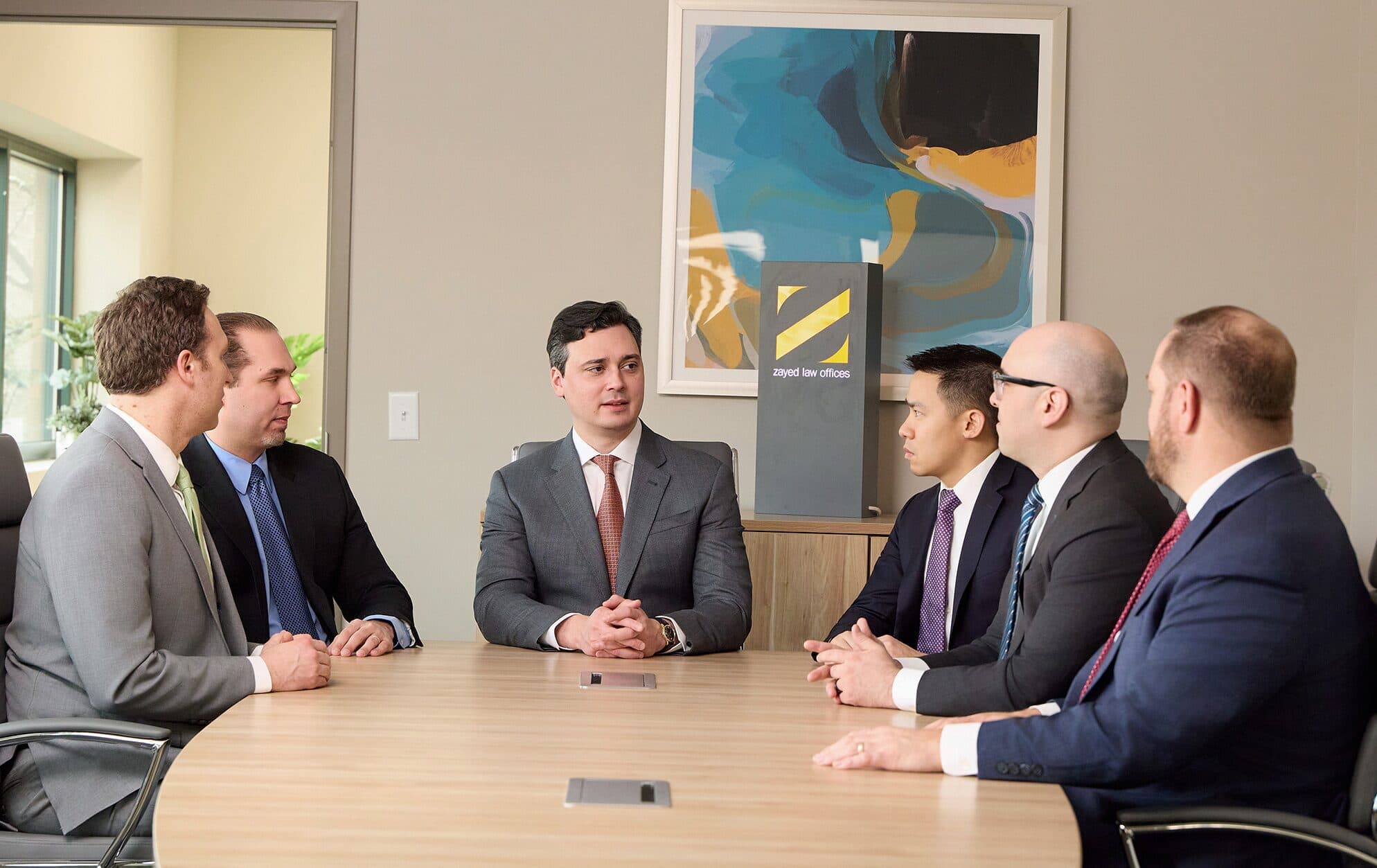 Attorneys of Zayed Law in conference around the firm's boardroom table